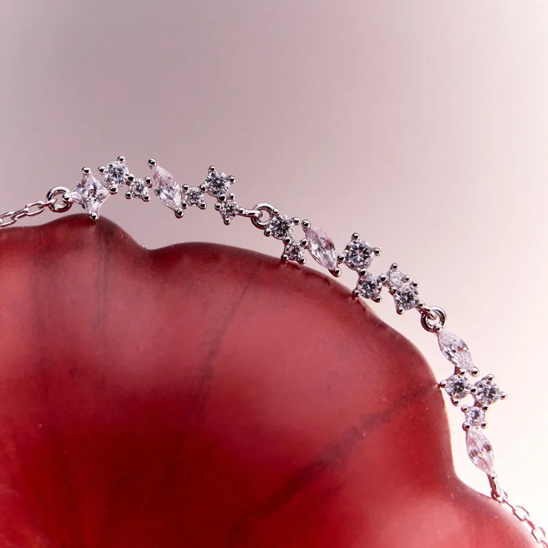 Close-up of the sterling silver Reflections of Water bracelet resting gracefully on a tomato, highlighting its sparkling CZ stones.