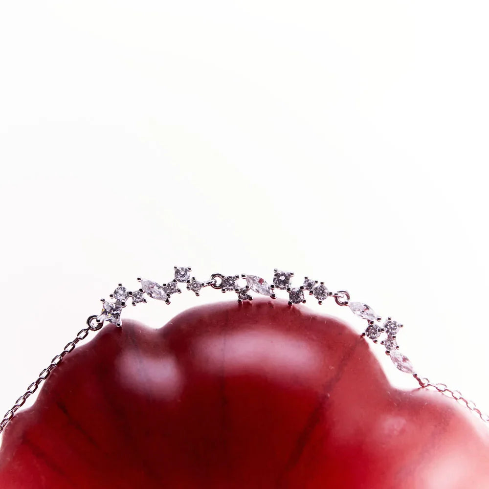 Close-up of the sterling silver Reflections of Water bracelet resting gracefully on a tomato, highlighting its sparkling CZ stones.