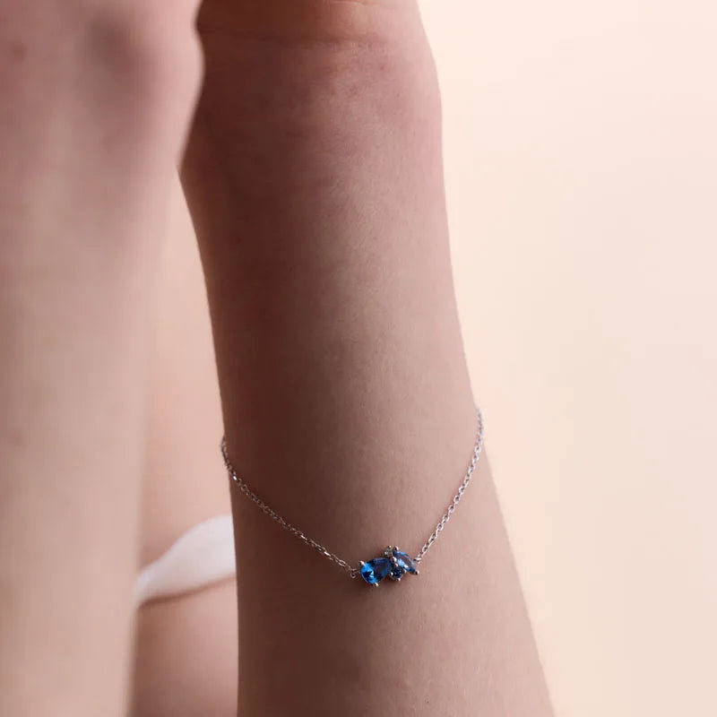 Elegant sterling silver bracelet with a trio of radiant blue topaz gemstones on a fine chain.