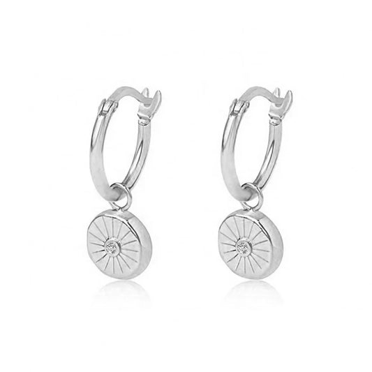 Sterling silver huggie earrings with a circular charm pendant featuring a sparkling cubic zirconia, perfect for everyday elegance or subtle evening glamour.