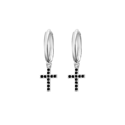 Sterling silver huggie earrings featuring a black cubic zirconia cross drop. Sleek and modern design, perfect for a monochromatic and sophisticated aesthetic, 20x6 mm.