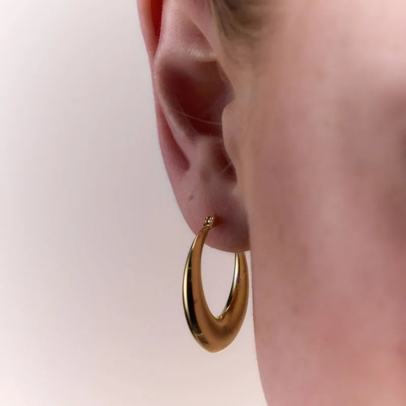 Side profile view of gold-plated tapered oval hoop earrings, showcasing their elegant taper and smooth polished finish.