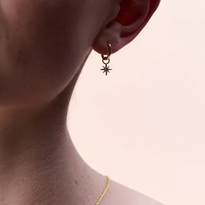 Side profile of a 9k yellow gold hoop earring with a diamond-studded star charm, perfect for a touch of elegance and sophistication.