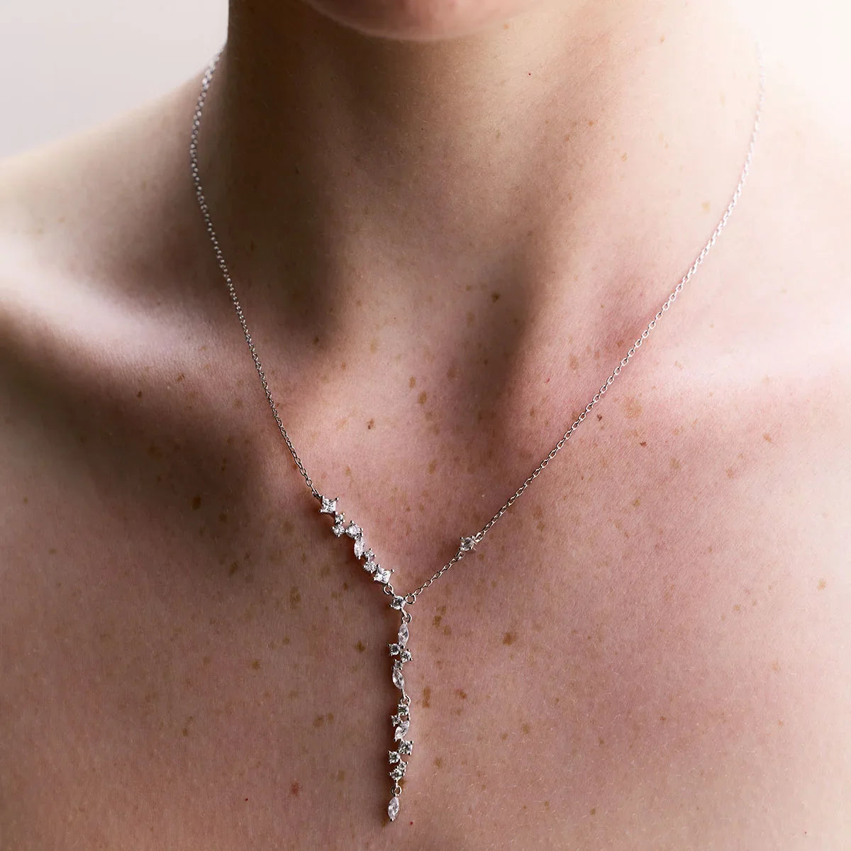 Sterling silver multistone necklace worn beautifully on a model, highlighting its cascading design and graceful shimmer.