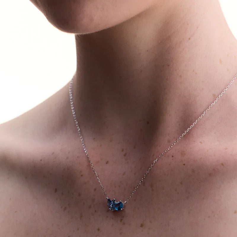 Blue topaz sterling silver necklace showcased on a model, highlighting its sophisticated design and sparkling gemstone charm.