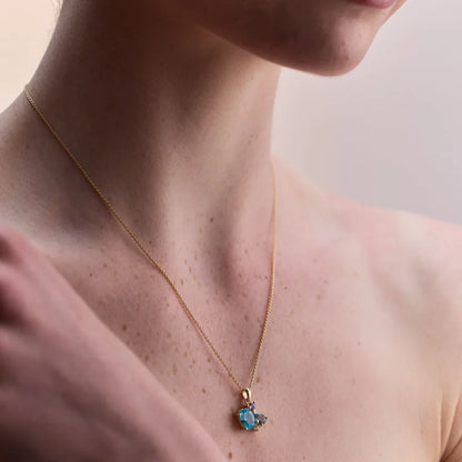 Model wearing a stunning gold-plated necklace adorned with blue topaz and amethyst gemstones, exuding elegance and charm.