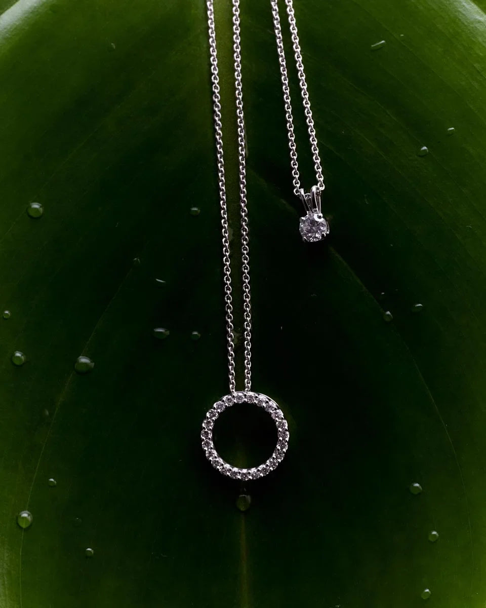 Side-by-side diamond circle and solitaire pendants on white gold chains, creating a perfect blend of classic and modern jewellery styles.