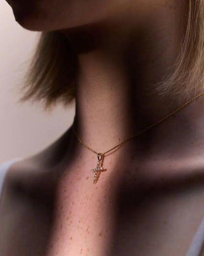 Side profile of a 9k yellow gold diamond cross pendant, showcasing its refined craftsmanship and delicate chain.