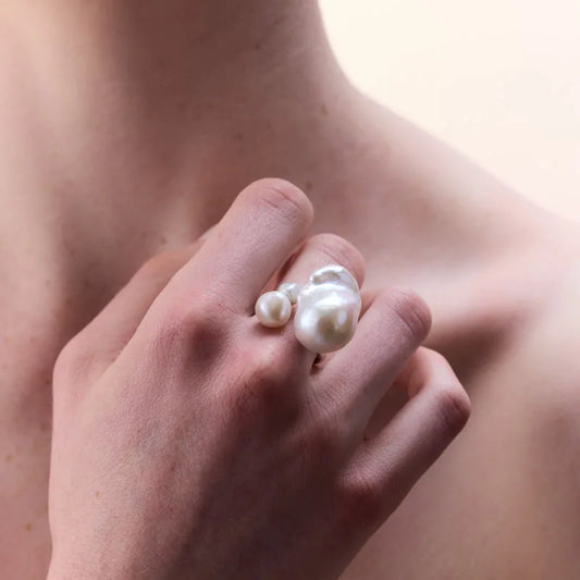 Close-up view of a sterling silver ring with uniquely shaped natural freshwater pearls, highlighting its bold design and intricate craftsmanship.