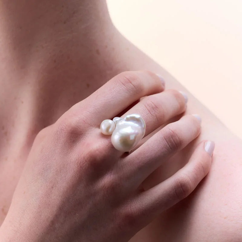 Sterling silver pearl ring worn on a hand, demonstrating its modern, organic look and sophisticated appeal.