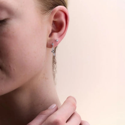 Elegant diamond stud earrings in 14k white gold with a classic claw setting, styled alongside drop earrings for versatile day-to-night wear.